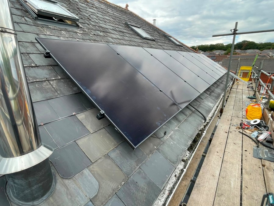 Solar panels installed on a slate roof with scaffolding in place