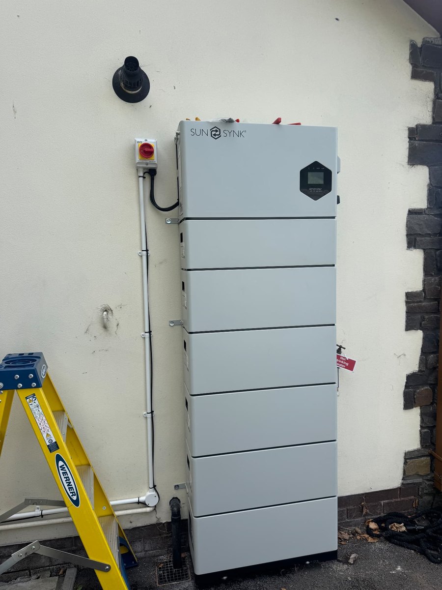 Tall Sunsynk battery tower installed against an external wall